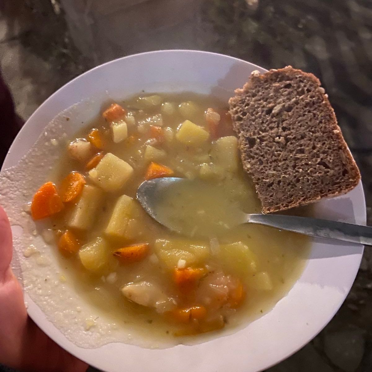 Gemüsesuppe mit Brot auf einem Teller