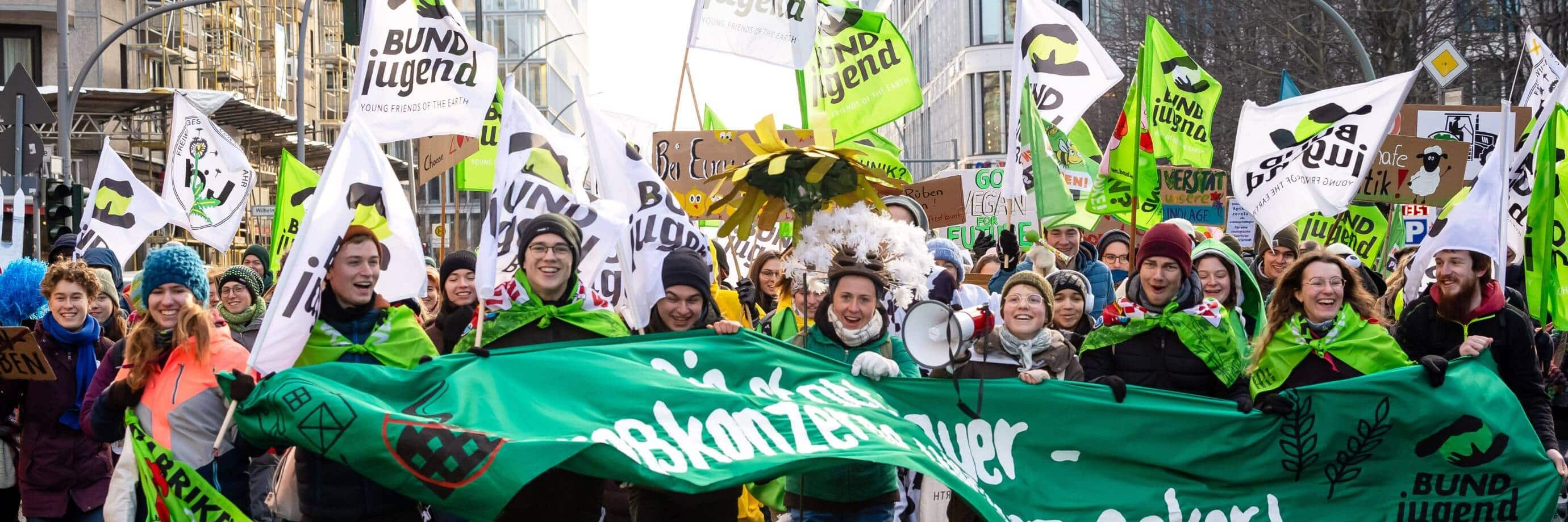 Menschen demonstrieren für Umweltschutz mit Bannern und Fahnen.